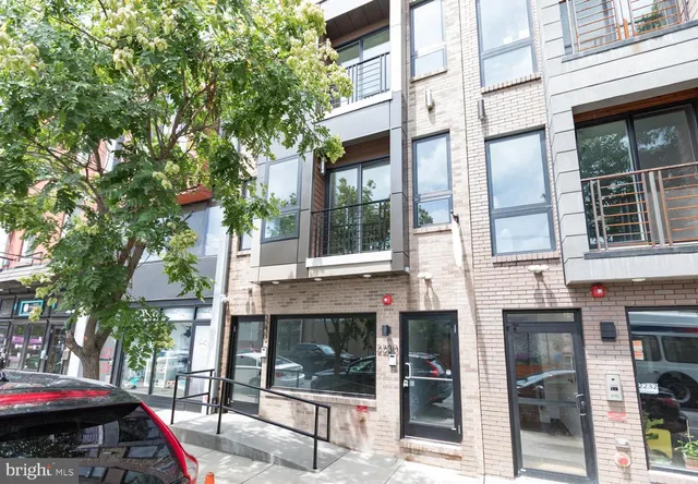 a front view of a building with a garden