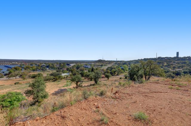 a view of a dry yard with mountains in the background