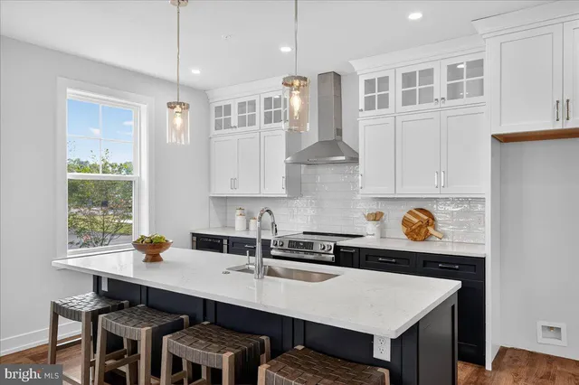 a kitchen with a sink a stove and wooden cabinets