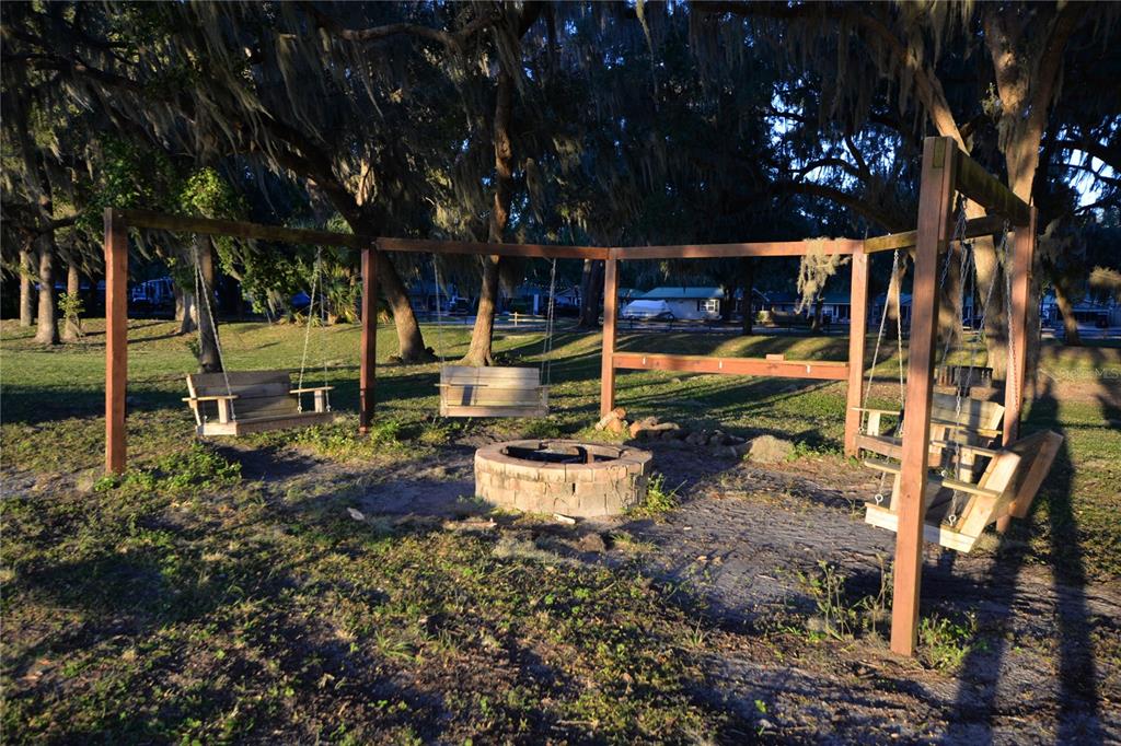 25144 Northeast 140th Loop Fort McCoy, FL 32134 - Photo 13 of 17 a view of a patio with table and chairs potted plants and large tree