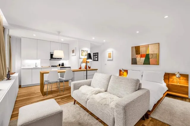 a living room with furniture and kitchen view