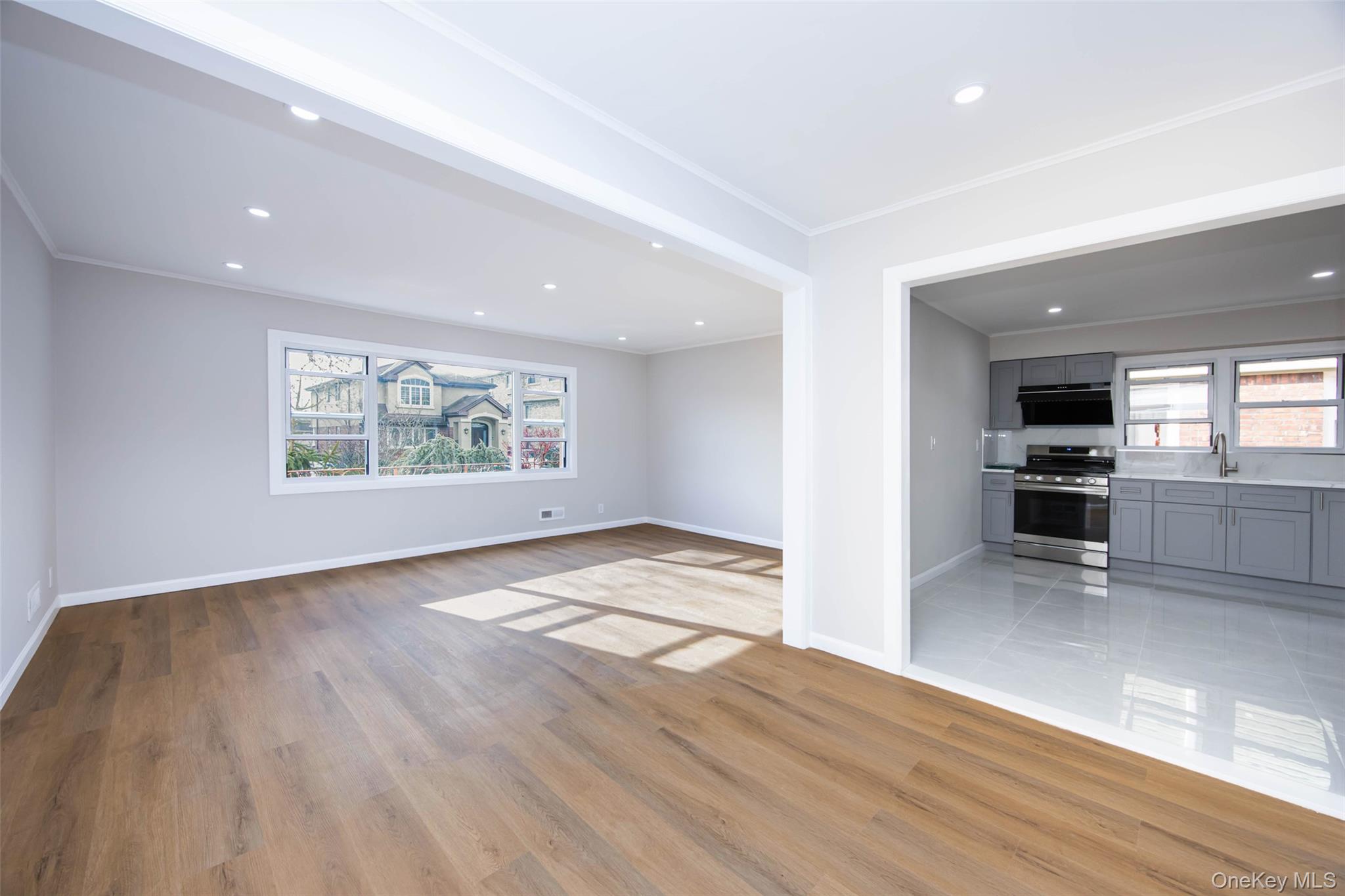 157-19 16th Road Queens, NY 11357 - Photo 11 of 33 an empty room with wooden floor and windows