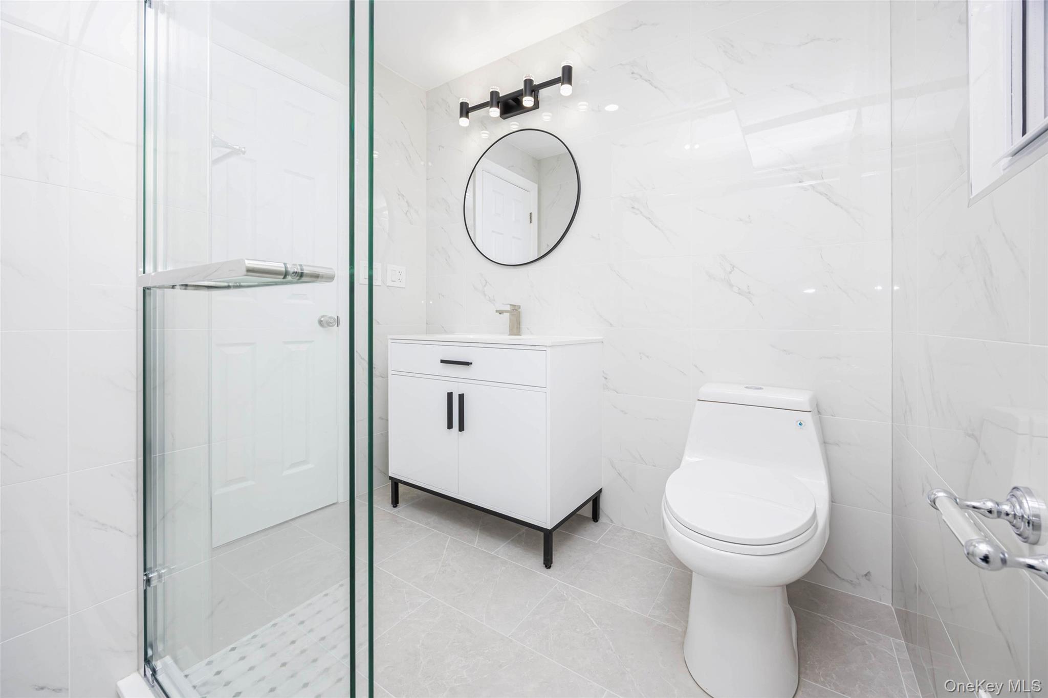 157-19 16th Road Queens, NY 11357 - Photo 14 of 33 a bathroom with a toilet sink vanity and mirror