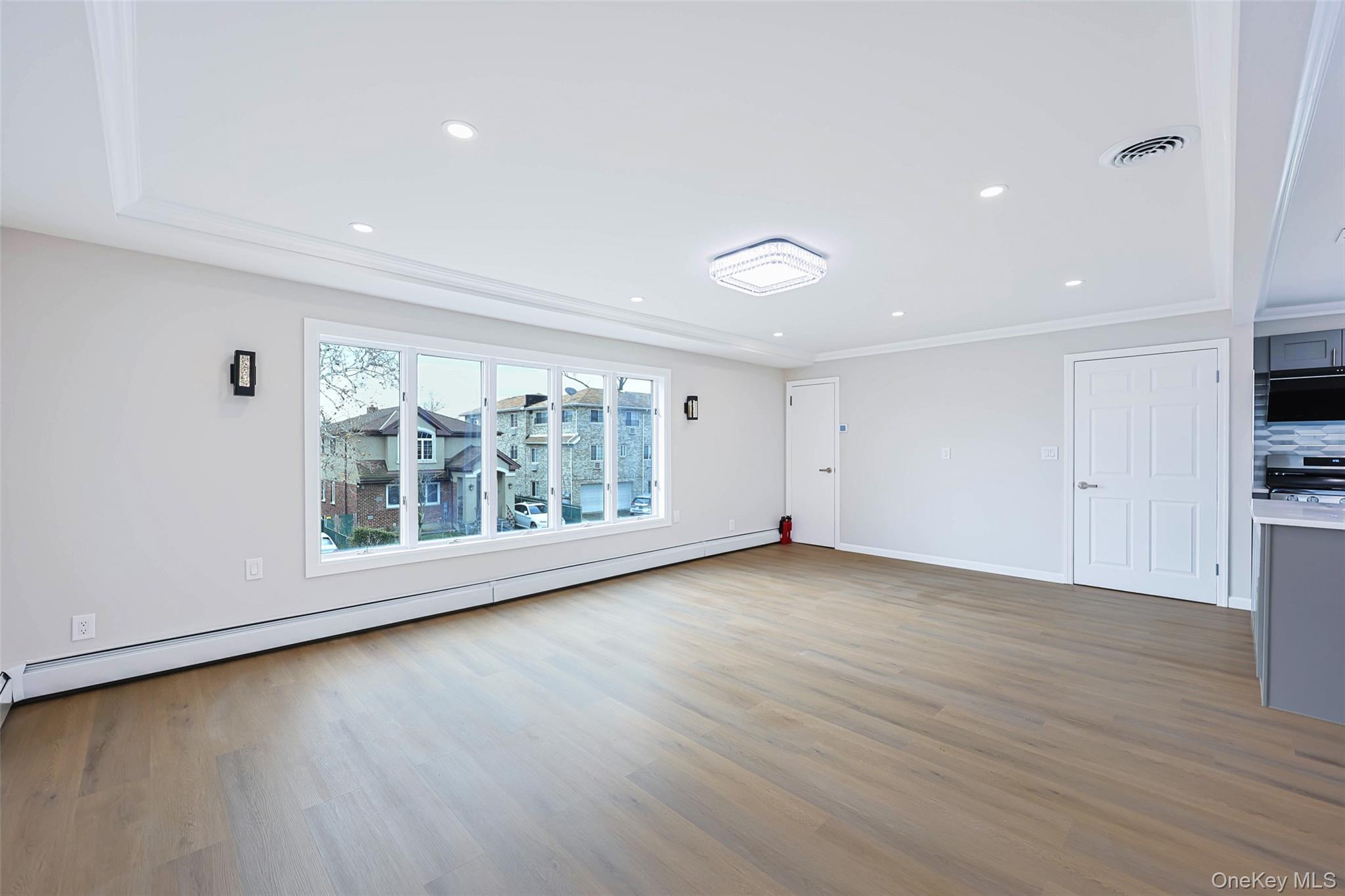 157-19 16th Road Queens, NY 11357 - Photo 24 of 33 a view of an empty room with wooden floor and a window