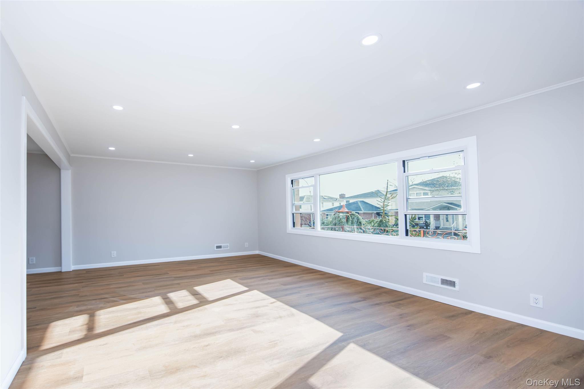 157-19 16th Road Queens, NY 11357 - Photo 9 of 33 an empty room with wooden floor and windows