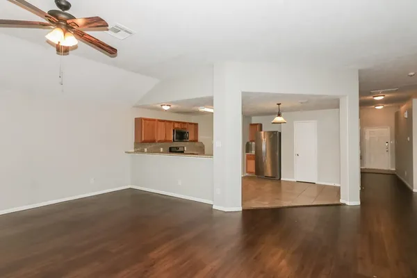 a view of a room with wooden floor and a ceiling fan