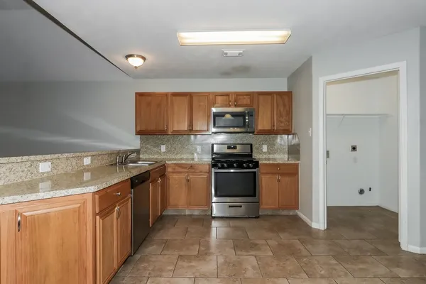 a kitchen with stainless steel appliances granite countertop a refrigerator stove and sink