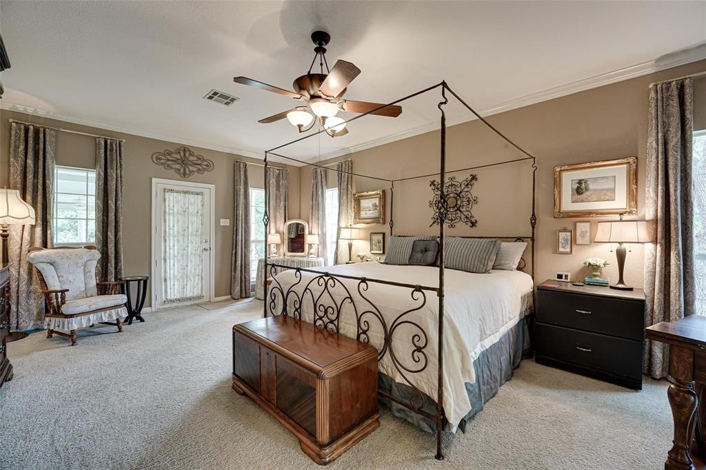 32018 Dove Trail Whitney, TX 76692 - Photo 14 of 36 a spacious bedroom with a bed a chandelier and dresser