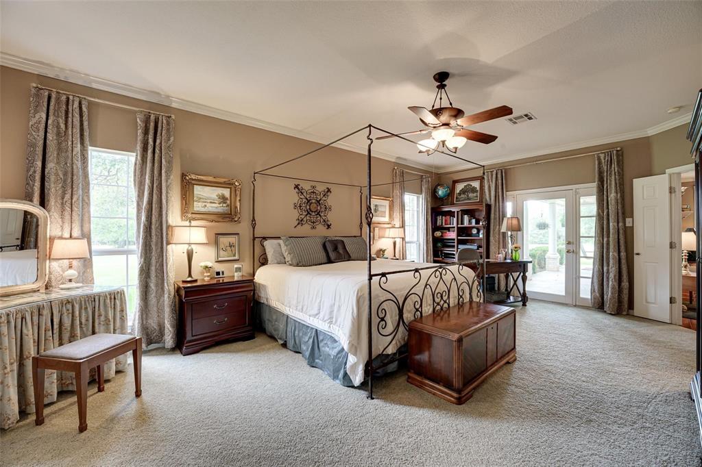 32018 Dove Trail Whitney, TX 76692 - Photo 15 of 36 a spacious bedroom with a bed and a chandelier