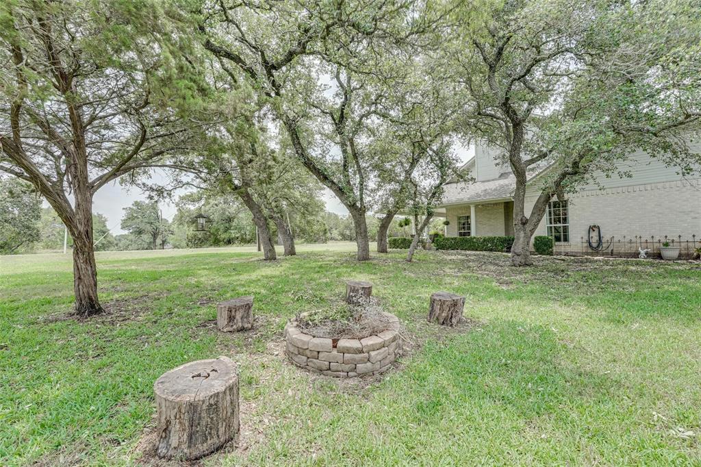 32018 Dove Trail Whitney, TX 76692 - Photo 30 of 36 a view of a backyard with table and chairs and a fire pit