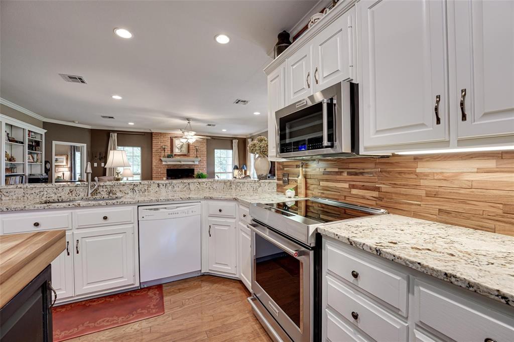 32018 Dove Trail Whitney, TX 76692 - Photo 7 of 36 a kitchen with granite countertop sink stainless steel appliances and white cabinets