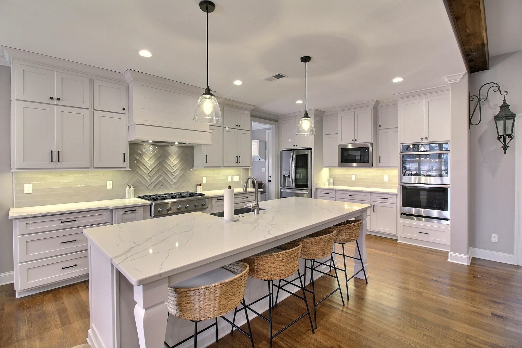 1254 Percheron Pass Collierville, TN 38017 - Photo 6 of 32 a kitchen with a sink a stove a refrigerator and white cabinets with wooden floor