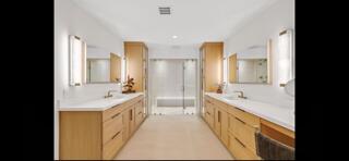 6110 North Ocean Boulevard, Unit 39 Ocean Ridge, FL 33435 - Photo 20 of 33 a bathroom with a double vanity sink and mirror with shower