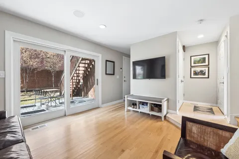 a living room with furniture a flat screen tv and a floor to ceiling window