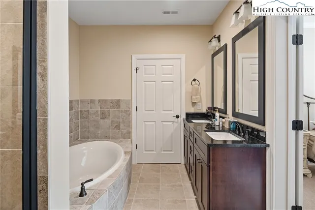 a bathroom with a bathtub a mirror a sink and vanity
