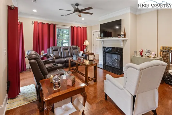 a living room with furniture a flat screen tv and a fireplace