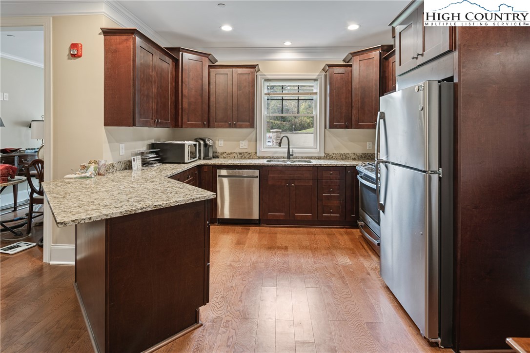 155 Gateway Drive, Unit 201 Boone, NC 28607 - Photo 9 of 23 a kitchen with stainless steel appliances granite countertop a refrigerator a sink a stove a microwave and island