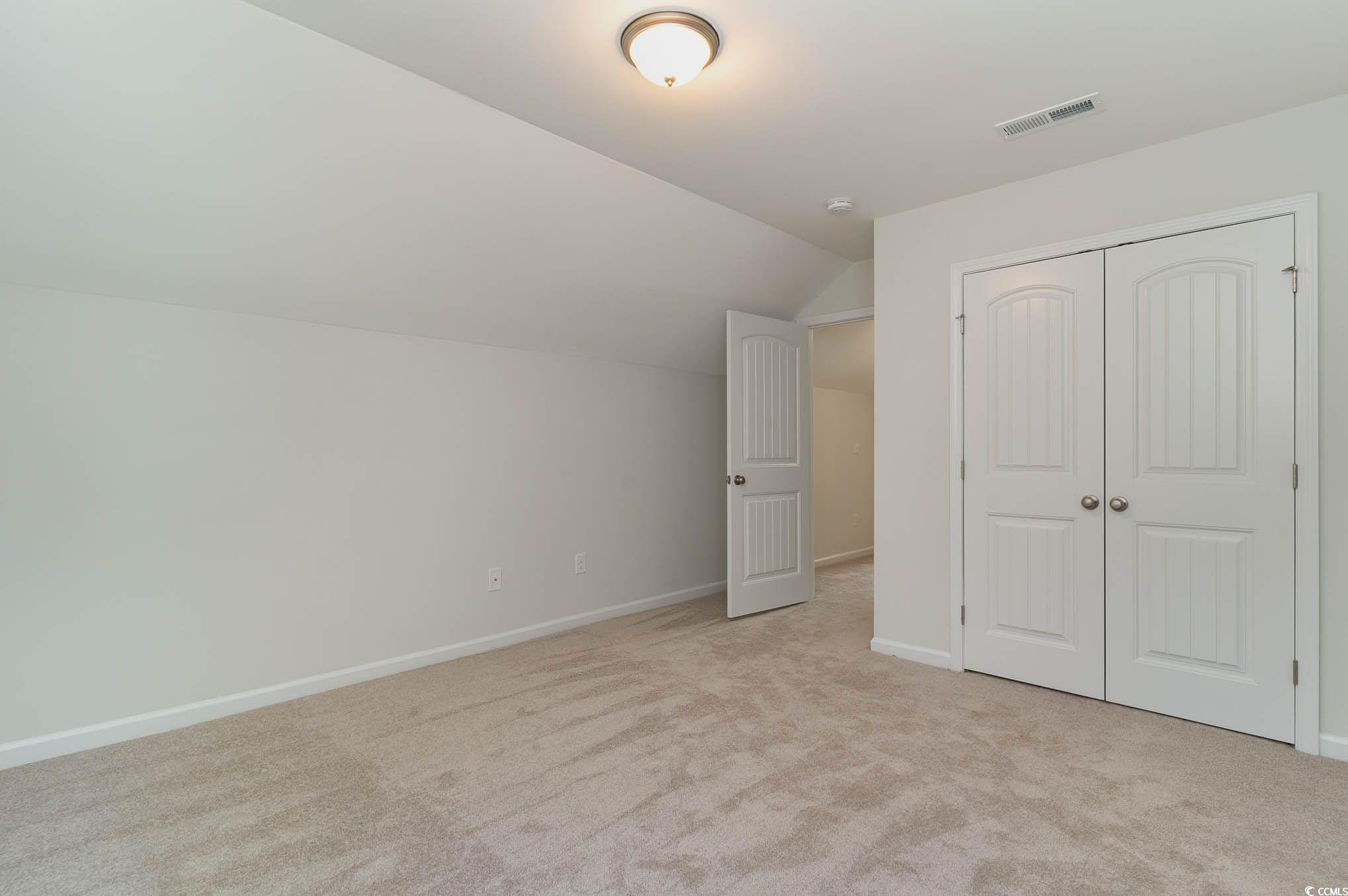 303 Lakota Loop Longs, SC 29568 - Photo 11 of 17 Unfurnished bedroom featuring lofted ceiling, ligh