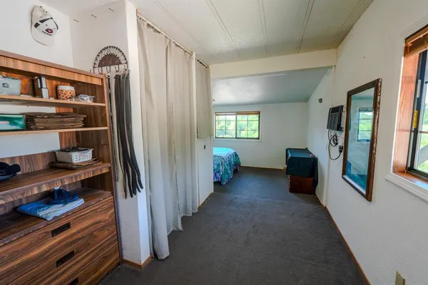 a view of a hallway to a livingroom with furniture