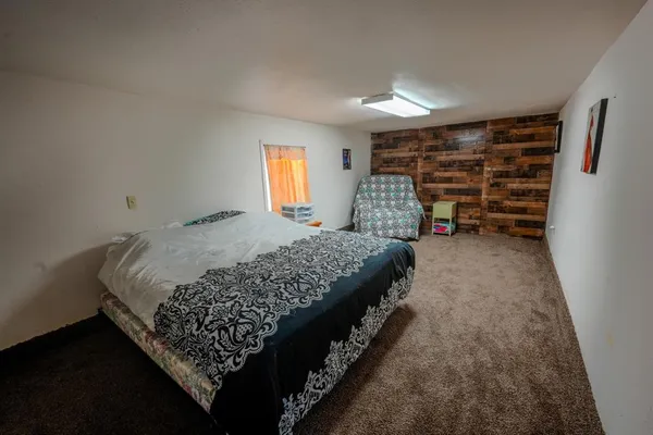 a bed sitting in a bedroom next to a window and a lamp