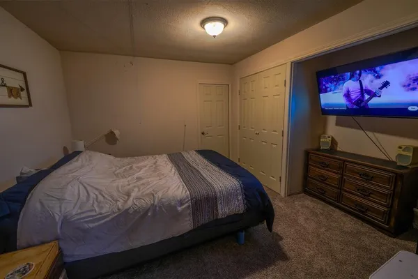 a bedroom with a bed and a flat screen tv