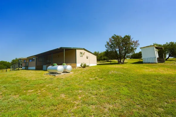 a view of a back yard of the house with green space