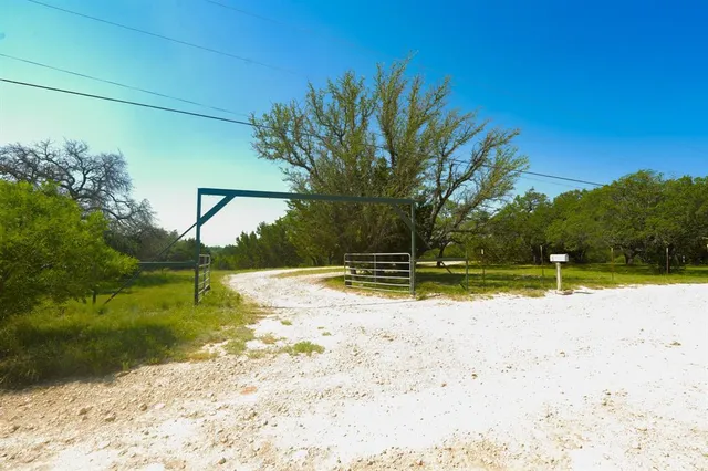 a view of yard with swimming pool and trees in the background