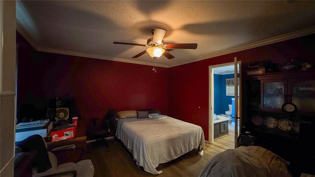 29040 Sentinel Street Nobleton, FL 34661 - Photo 14 of 21 a bedroom with a bed and a chandelier