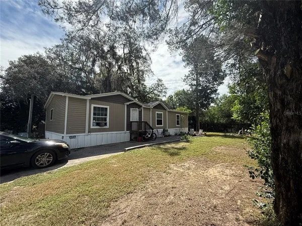 a view of a house with backyard and a tree