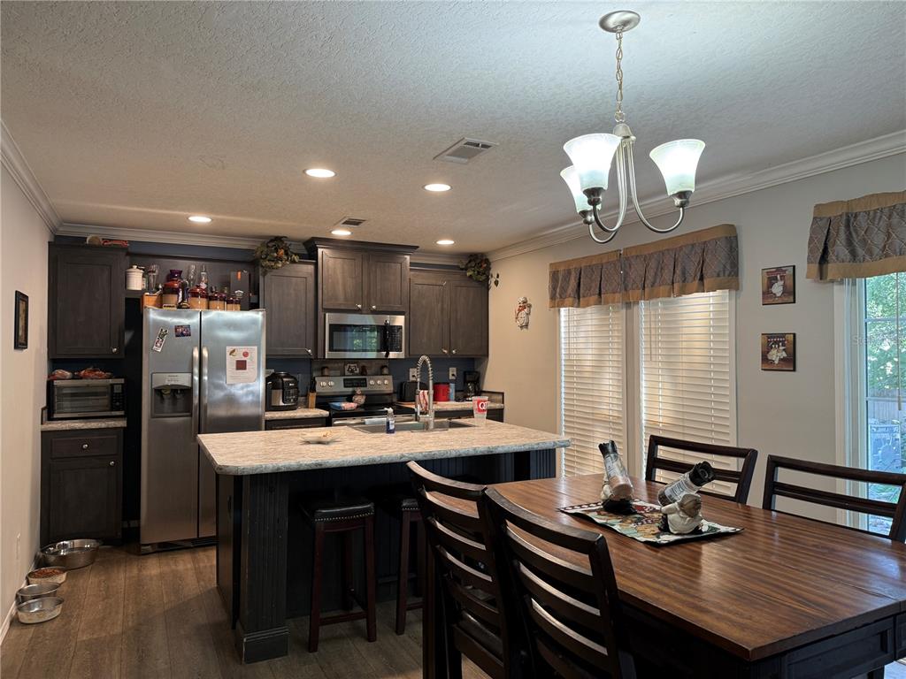 29040 Sentinel Street Nobleton, FL 34661 - Photo 8 of 21 a kitchen with a dining table chairs stainless steel appliances and cabinets