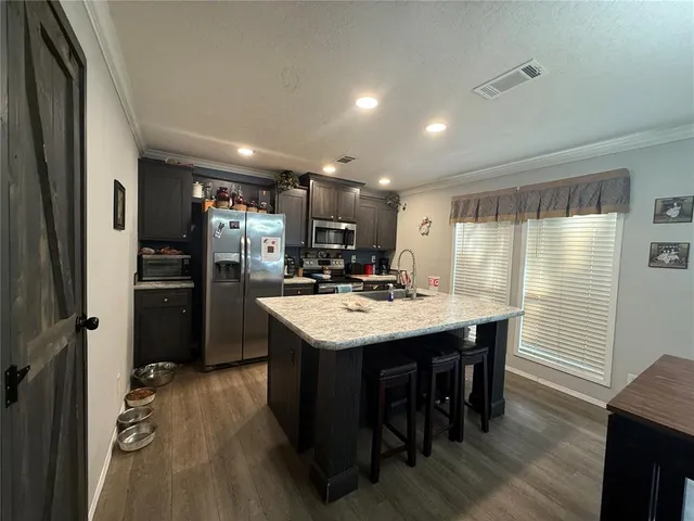 a kitchen with kitchen island a sink stove and refrigerator
