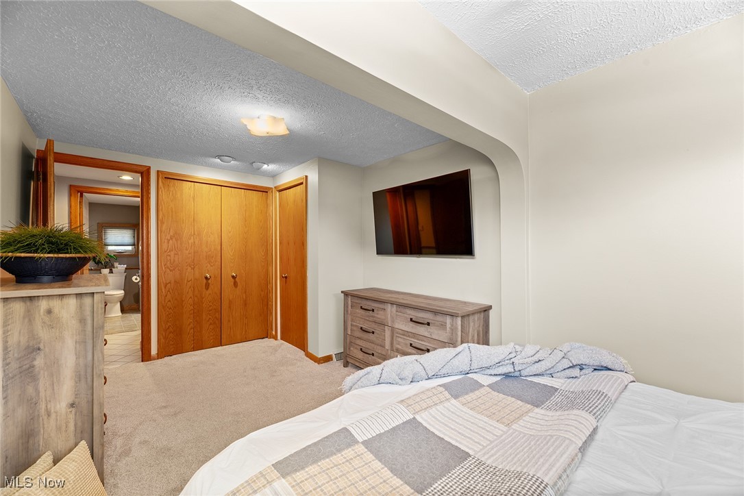 430 Stanley Road Akron, OH 44312 - Photo 15 of 36 Bedroom featuring a textured ceiling, light carpet, and a closet