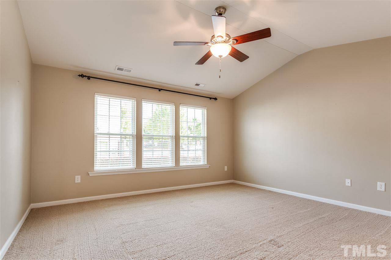 8702 Braxwood Place Raleigh, NC 27617 - Photo 13 of 24 an empty room with a window and a ceiling fan
