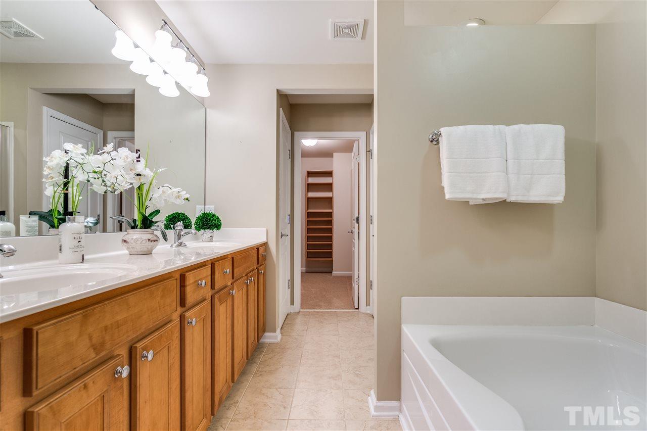 8702 Braxwood Place Raleigh, NC 27617 - Photo 14 of 24 a bathroom with a bathtub sink and mirror