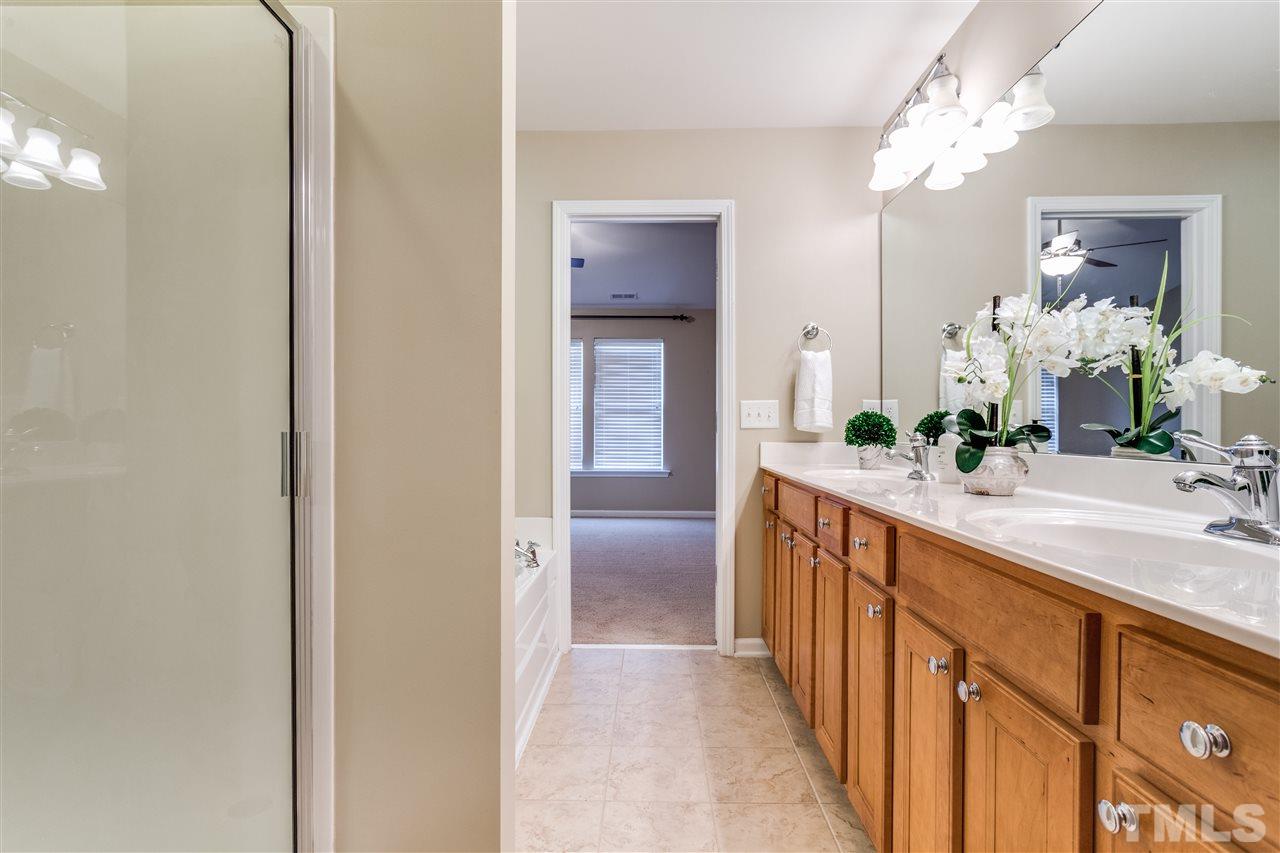 8702 Braxwood Place Raleigh, NC 27617 - Photo 17 of 24 a bathroom with a double vanity sink and a mirror