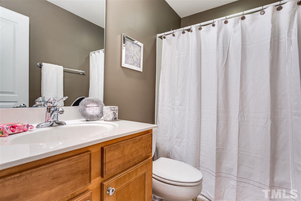 8702 Braxwood Place Raleigh, NC 27617 - Photo 19 of 24 a bathroom with a sink a toilet and shower curtain
