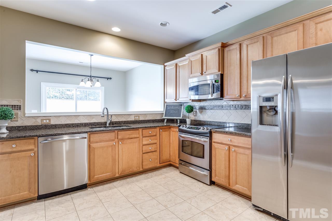 8702 Braxwood Place Raleigh, NC 27617 - Photo 8 of 24 a kitchen with granite countertop stainless steel appliances a sink and a refrigerator