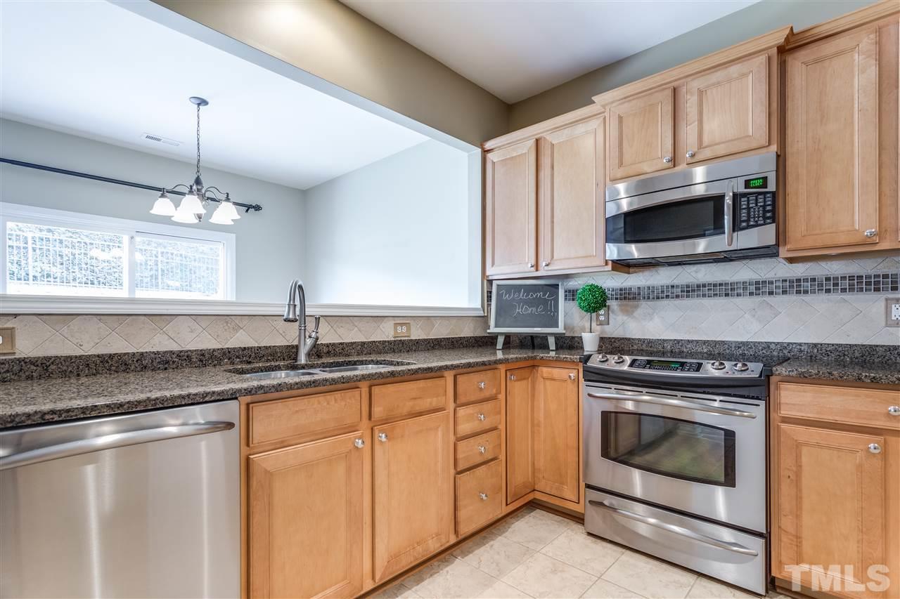 8702 Braxwood Place Raleigh, NC 27617 - Photo 10 of 24 a kitchen with granite countertop white cabinets white stainless steel appliances a sink and a window