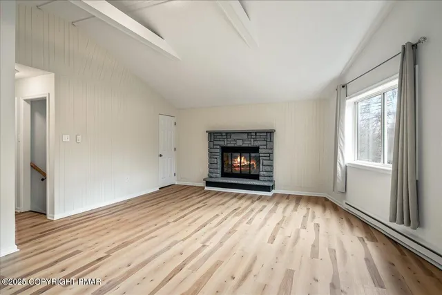 wooden floor fireplace and windows in an empty room