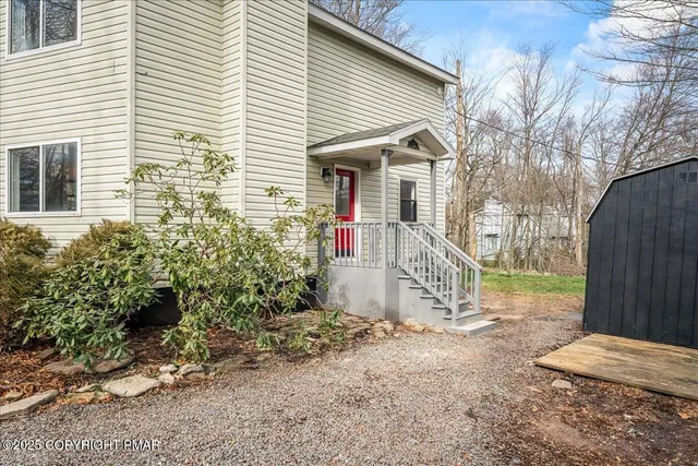 a view of a house with a yard and lawn chairs