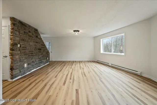 a view of a room with wooden floor and white walls