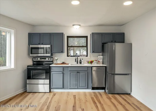 a kitchen with granite countertop a refrigerator stove and microwave