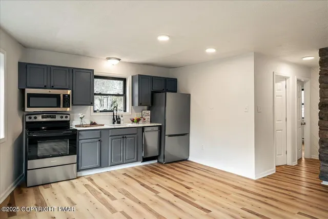 a kitchen with stainless steel appliances granite countertop a refrigerator sink and stove