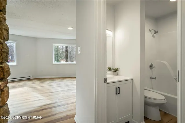 a bathroom with a sink a toilet and shower