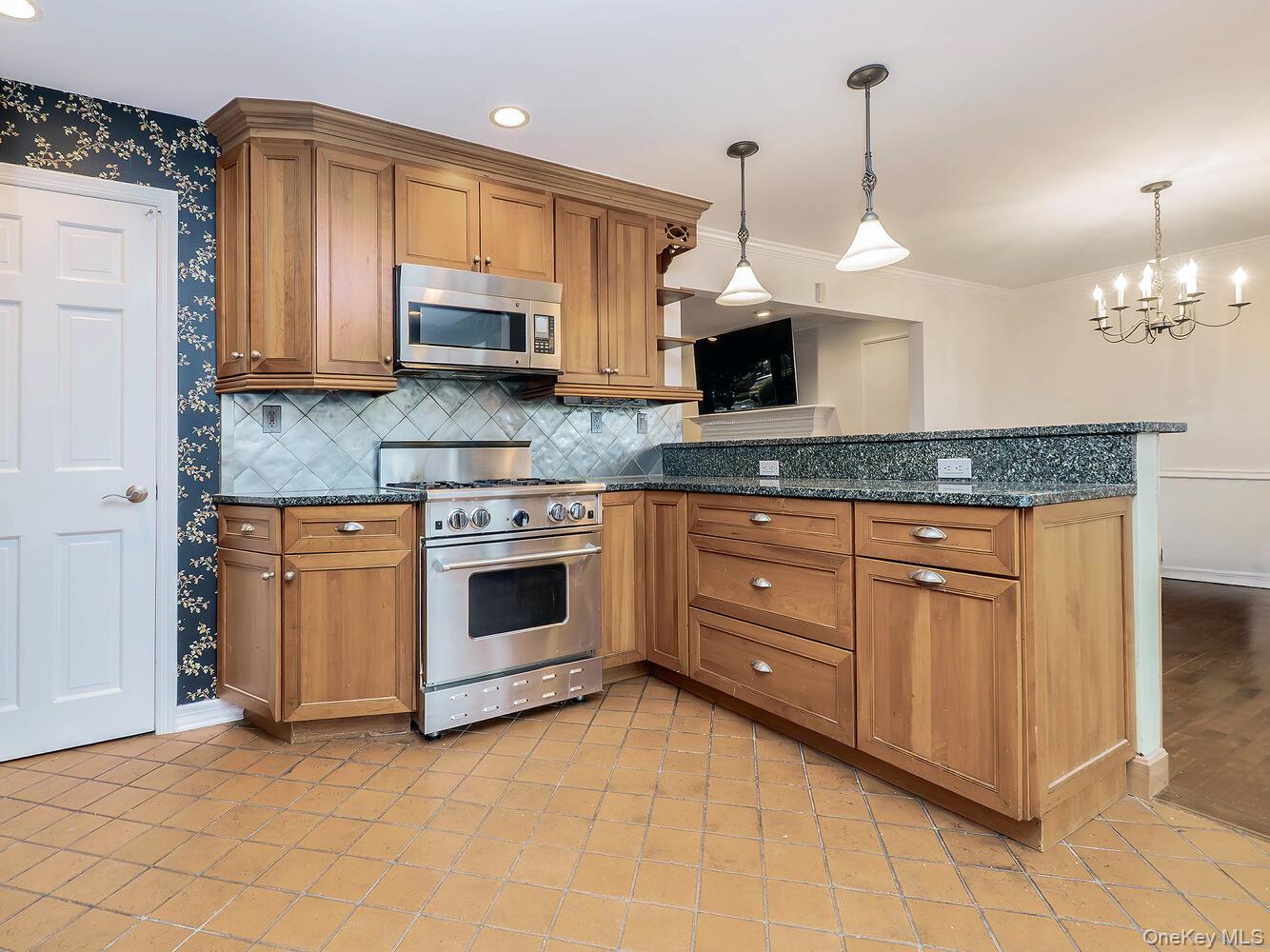 41 South 4th Street Locust Valley, NY 11560 - Photo 11 of 39 Kitchen featuring brown cabinetry, appliances with stainless steel finishes, tasteful backsplash, dark stone countertops, and recessed lighting