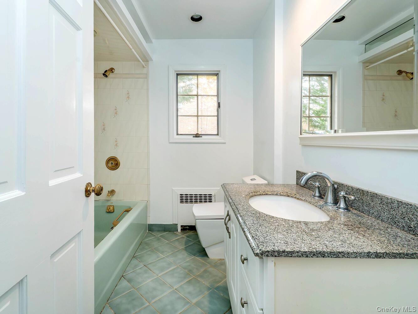 41 South 4th Street Locust Valley, NY 11560 - Photo 17 of 39 Bathroom with shower / tub combination, vanity, radiator, dark tile patterned floors, and plenty of natural light
