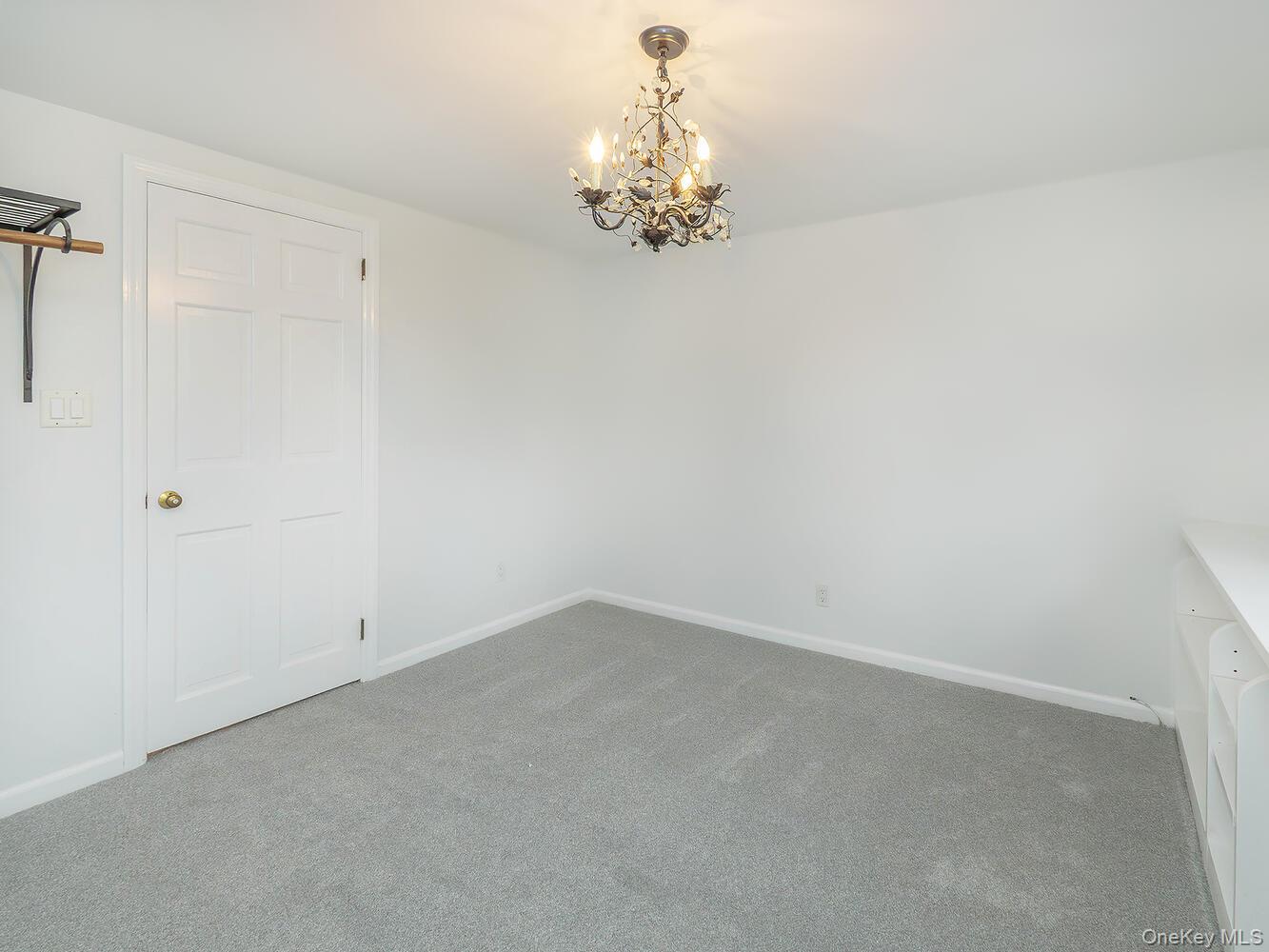 41 South 4th Street Locust Valley, NY 11560 - Photo 18 of 39 Unfurnished bedroom with carpet and a chandelier