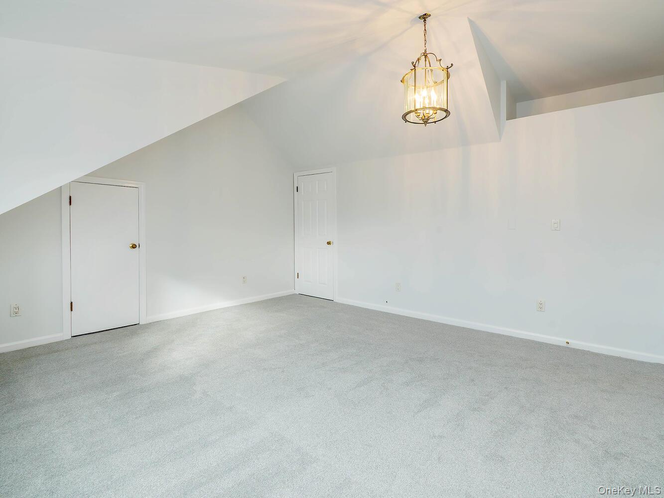 41 South 4th Street Locust Valley, NY 11560 - Photo 21 of 39 Bedroom with vaulted ceiling, light carpet, and a chandelier