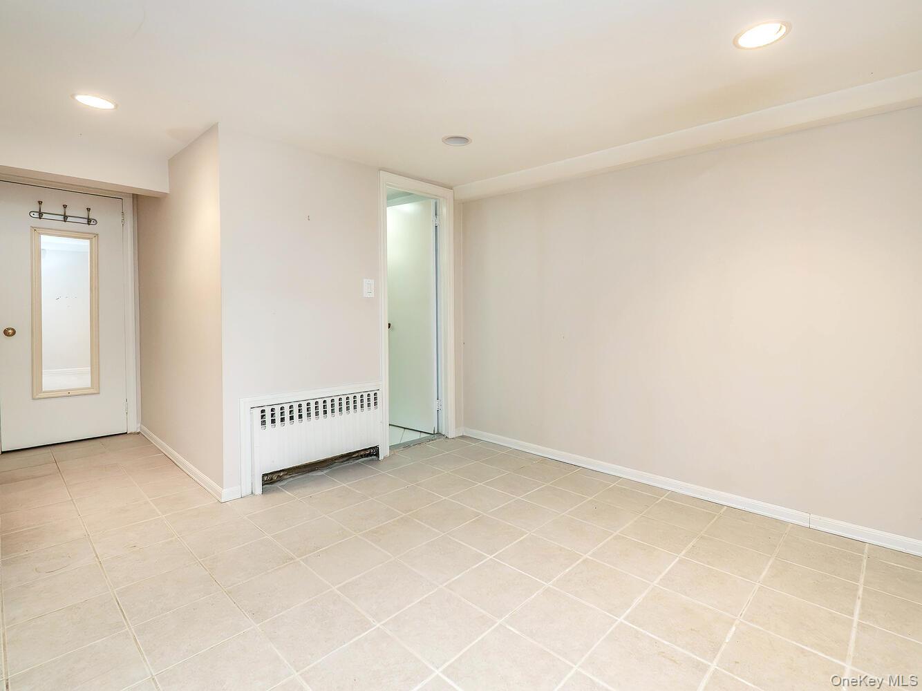 41 South 4th Street Locust Valley, NY 11560 - Photo 31 of 39 Unfurnished room featuring radiator, recessed lighting, and light tile patterned floors