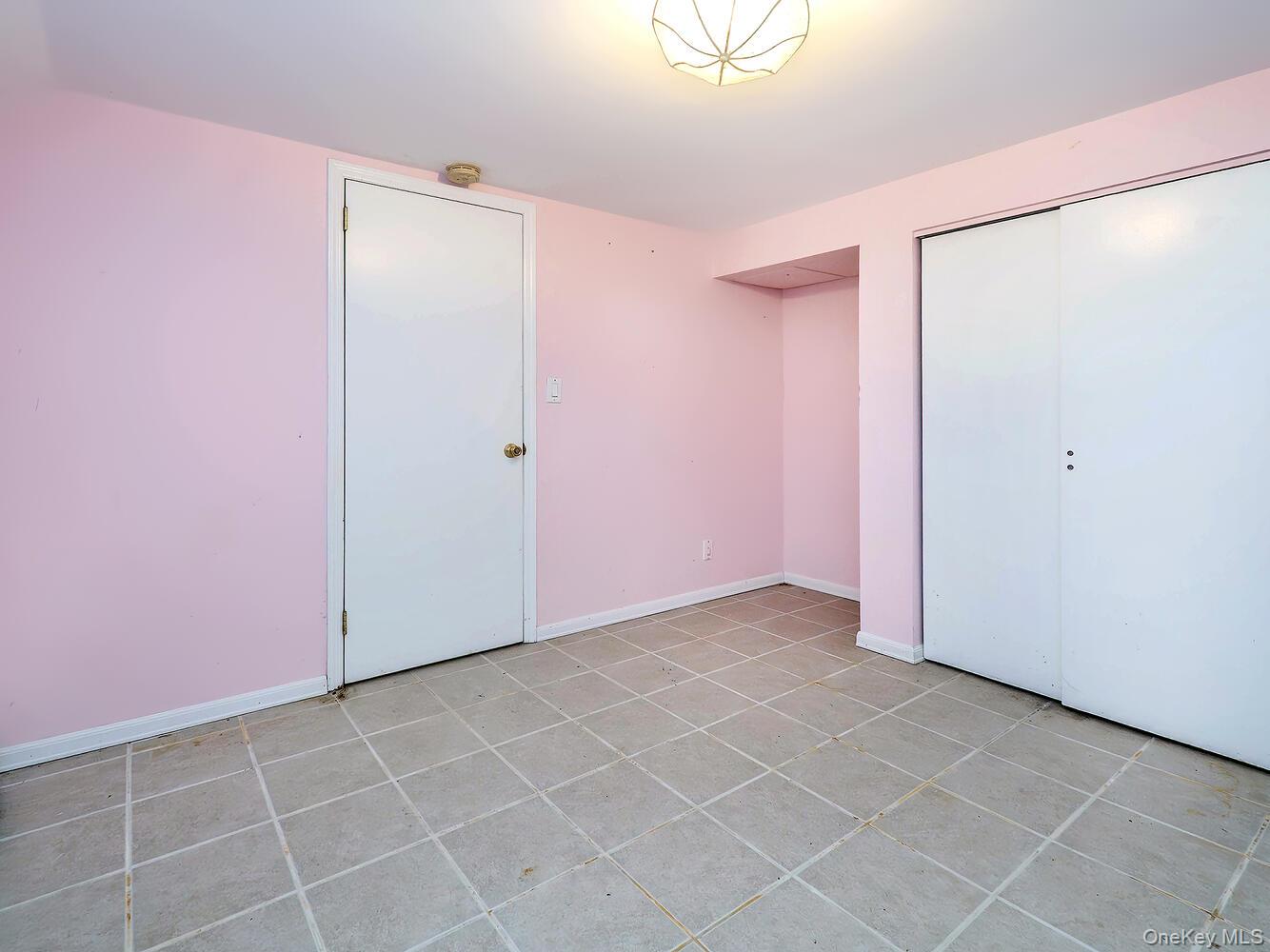 41 South 4th Street Locust Valley, NY 11560 - Photo 33 of 39 Unfurnished bedroom featuring light tile patterned floors and a closet